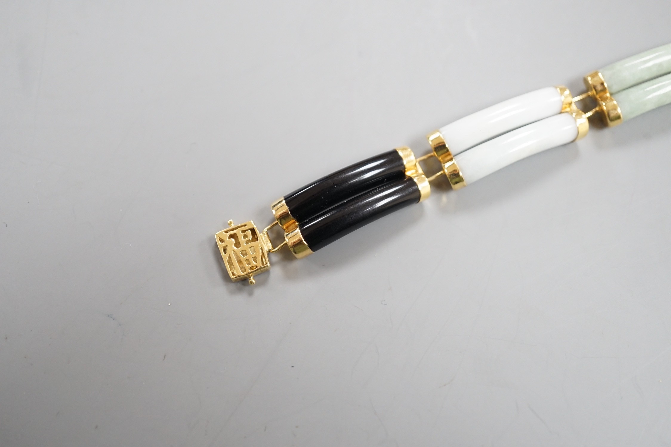 A Chinese 18k, black onyx and multi coloured jade set bracelet, 17.75cm, gross weight 20 grams.